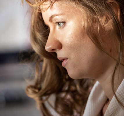 Georgia Aussenac profile photo, with perfectly prepped skin and blonde curls falling around her face, wearing a white robe.